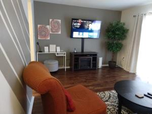 sala de estar con silla y TV en Exclusive Townhome - Central Raleigh Location en Raleigh