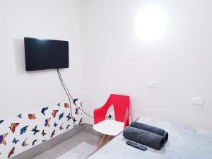 a bedroom with a red chair and a tv at Perth City Motel in Perth