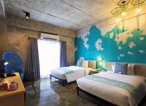 a bedroom with two beds and a blue wall at The Henry Hotel Cebu in Cebu City