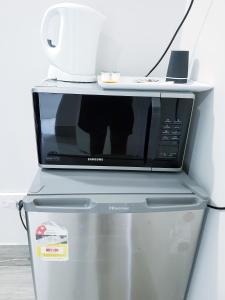 a microwave sitting on top of a refrigerator at Perth City Motel in Perth