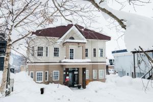 una casa ricoperta di neve con alberi innevati di Absolute Niseko Lodge a Niseko