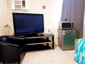 a flat screen tv sitting on a stand with a microwave at Perth City Motel in Perth