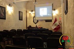 una sala de conferencias con una pantalla con sillas y un podio en Hotel Santa Rosa, en Arequipa