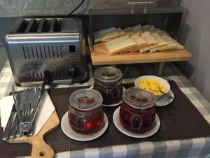 望加錫的住宿－馬卡薩艾克普利西亞酒店，一张桌子,上面放有果酱盘子和面包,还有烤面包机
