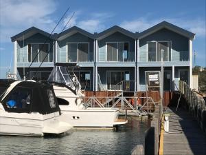 a boat is docked in front of a house at Marina View Chalets in Wannanup