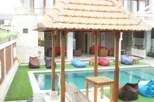 a gazebo next to a swimming pool at Oka's Guest House Canggu in Canggu