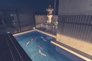 um grupo de pessoas a nadar numa piscina em Zen Kyoto Apartment Hotel em Quioto