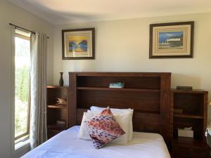 a bedroom with a bed with a wooden headboard at Apple House in Tarneit
