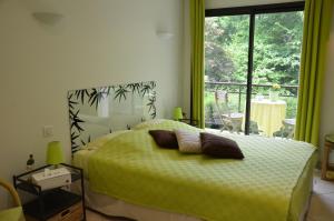 a bedroom with a bed with green sheets and a window at La Villa Antalya in Ault