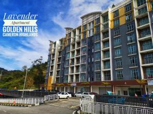 ein großes Gebäude mit Autos auf einem Parkplatz in der Unterkunft Lavender Apartment 1BR Golden Hills Cameron Highlands in Cameron Highlands