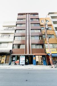un edificio alto en la esquina de una calle en Shirakabanoyado - Doutonbori 道頓堀, SELF CHECK IN ONLY, en Osaka