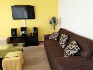 sala de estar con sofá y TV de pantalla plana en Miraflores Rentals LarcoMar, en Lima