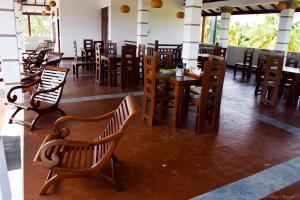 a restaurant with wooden chairs and tables in a room at Tenasi Beach Resort in Ahangama