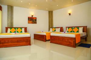 um quarto com três camas num quarto em Elegance Range Resort em Kandy