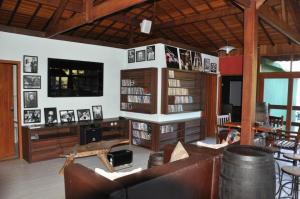 a living room with a couch and a book shelf at Pousada Villa Acauã in Visconde De Maua