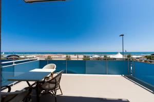 a patio with a table and chairs and the beach at Hotel Sayonara in Senigallia