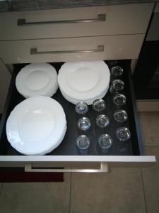 four white plates and silver bowls in a drawer at boyard in Rochefort