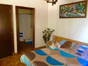 Un dormitorio con una cama con un cuadro en la pared. en Studio duplex 1 Lac des Montagnès, en Mazamet