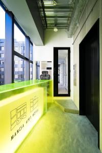 a lobby with a green counter in a building at MANGA ART HOTEL, TOKYO in Tokyo