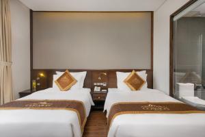 Postelja oz. postelje v sobi nastanitve Cosmos Hotel Danang