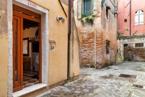 eine Gasse mit offener Tür in einem alten Gebäude in der Unterkunft Antico Caminetto alla Biennale in Venedig