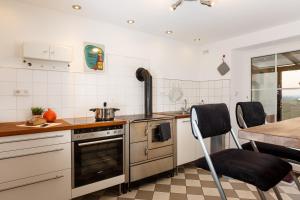 a kitchen with a stove and a table and chairs at Auszeit-Eifel Eifelhaus "Burgaß 1807" Sauna & Badezuber in Willwerscheid +23 photos
