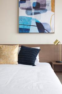 布里斯本的住宿－The Metropolitan Spring Hill，卧室配有一张床,墙上挂有绘画作品