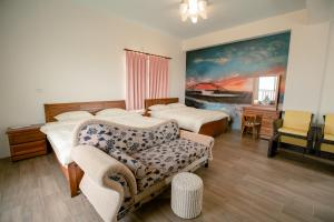 馬公市的住宿－澎湖太陽民宿，一间卧室配有两张床、一张沙发和一把椅子