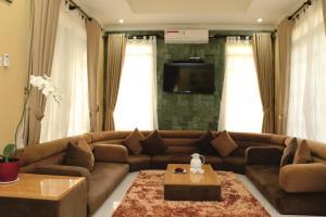 a living room with a brown couch and a table at Diyar Villas Puncak M6/12 in Puncak