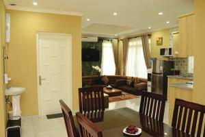 a kitchen and living room with a couch and a table at Diyar Villas Puncak M6/12 in Puncak