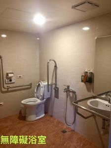 łazienka z toaletą i umywalką w obiekcie Lo Fo Hotel w mieście Taizhong