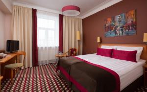 una habitación de hotel con una cama grande con almohadas rojas en Oktiabrskaya Hotel, en San Petersburgo