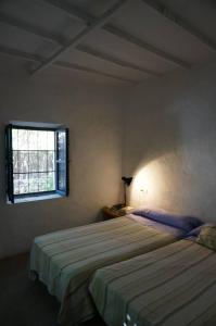 - une chambre avec 2 lits et une fenêtre dans l'établissement Casa de la Buganvilla, à Rodalquilar