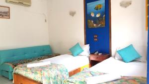 two beds in a room with blue and white at Neptune Hotel in Dahab