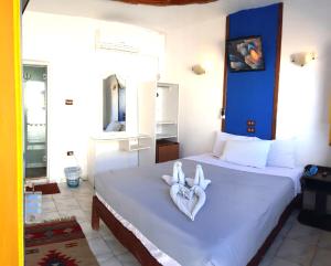 a bedroom with two heart shaped towels on a bed at Neptune Hotel in Dahab