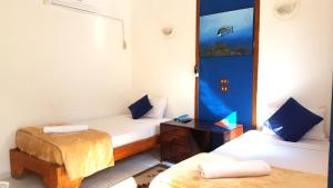 a room with two beds and a fish tank on the wall at Neptune Hotel in Dahab