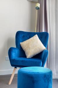 a blue chair with a pillow and a blue stool at The Metropolitan Spring Hill in Brisbane