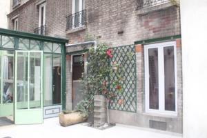 un edificio con una puerta verde y una planta en STYLE HOTEL, en París