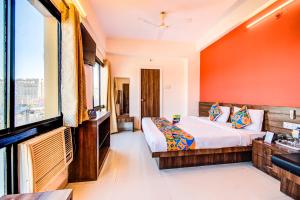 um quarto de hotel com uma cama e uma televisão de ecrã plano em FabHotel Kumar Vijay Nagar em Indore