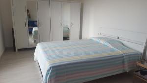 1 dormitorio con 1 cama con manta a rayas en Casa Vacanze Mercolino en Bracigliano