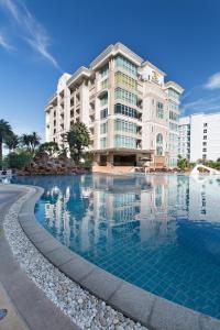 a hotel with a swimming pool in front of a building at Beautiful Apartment D6 Central Pattaya in Pattaya Central