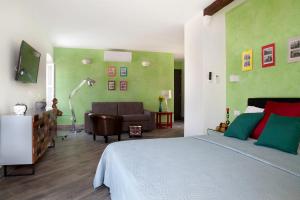 um quarto com uma cama e uma sala de estar com um sofá em Relais Al Porto em Peschiera del Garda