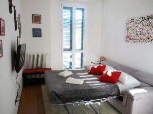 een slaapkamer met een bed met rode en witte kussens bij Casa "Le Cascine", comfortable apartment... in Florence