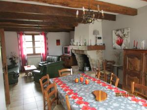 a dining room and living room with a table and a fireplace at GRAND GITE RURAL in Salmiech