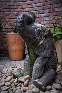 una estatua de un elefante sentado en un montón de rocas en Treetops Guesthouse, en Port Elizabeth