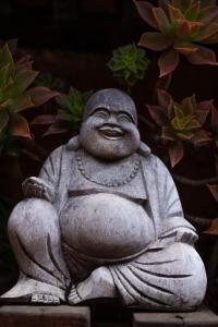 a stone statue of a monk sitting down at Treetops Guesthouse in Port Elizabeth