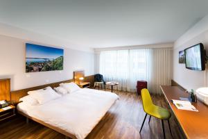 a hotel room with a large bed and a desk at City Hotel Biel Bienne Free Parking in Biel