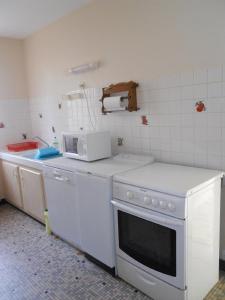 a kitchen with a white stove and a microwave at La palombe in Mimizan-Plage