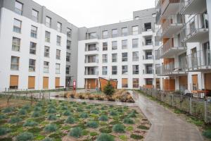 an apartment building with a garden in front of it at Apartament Smolna - Zawady in Poznań