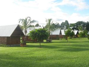 un groupe de maisons dans un champ d'herbe dans l'établissement Pousada Corujas, à Itu